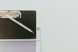 A clipboard resting in a holder on the wall.