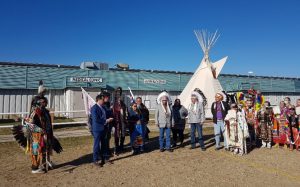 A group of people standing outside the Akamihk Health Care Services clinic at the grand opening in 2022.